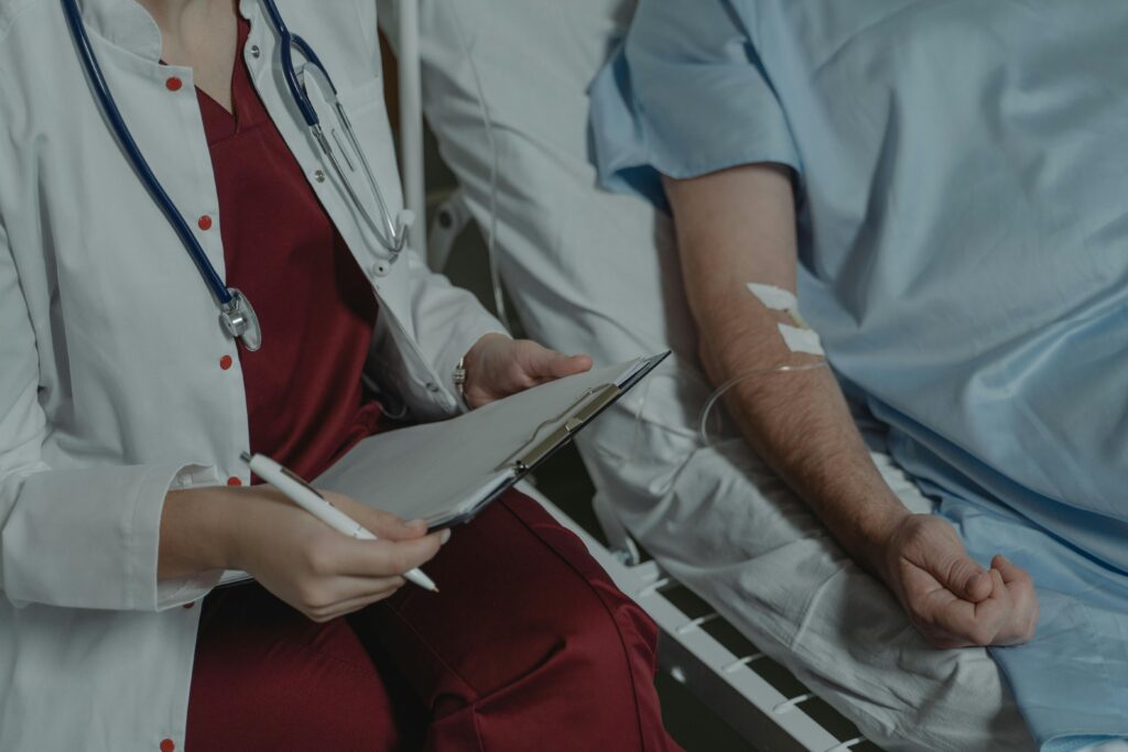 Médico consultando historial clínico de un paciente en un hospital de Málaga para explicar coberturas de seguro sin copagos.