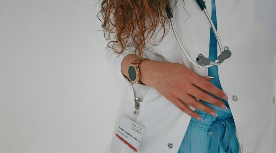 Médico con bata blanca y estetoscopio preparado para una consulta médica en un hospital.