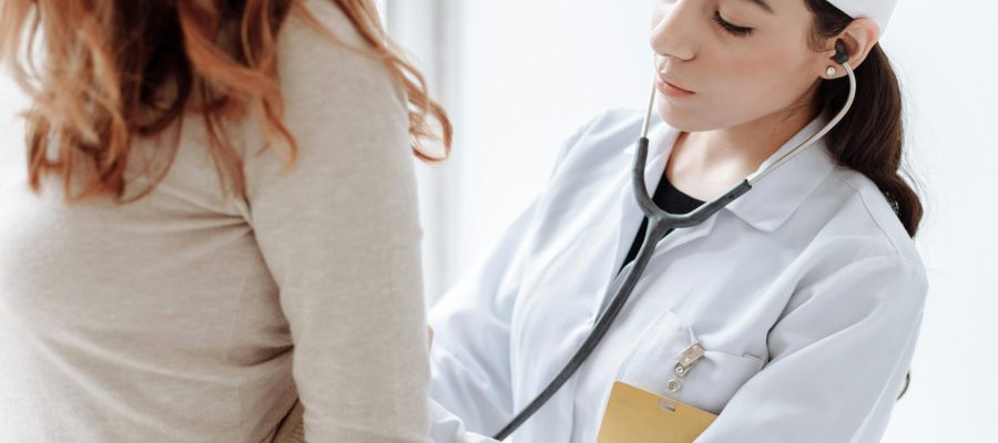 Médico realizando una auscultación a una paciente durante una revisión de Primero Salud.